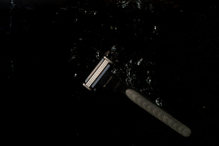 razor in water splashing with black background and copy space