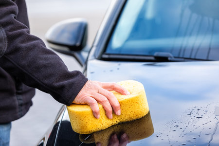 Car wash with a yellow soft spongeの写真素材