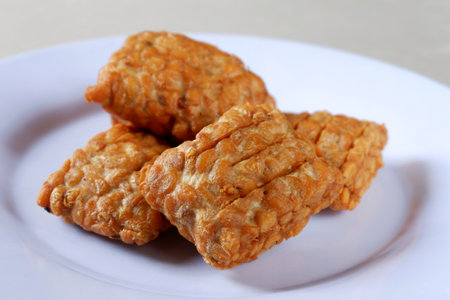Fried tempeh on a white plate ready to eat, Indonesian food