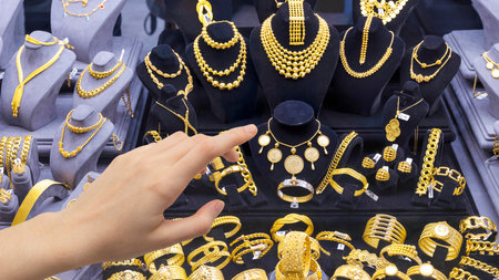 Shopping woman chooses jewelry in store. Woman looking to showcase or shop window.の写真素材