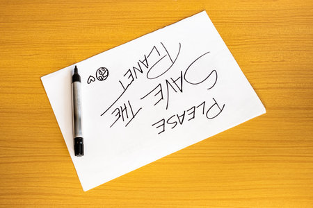 illustration of a sheet of paper written with the message Save the planet and a marker next to it....