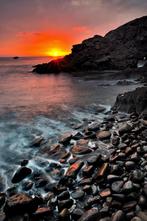 Tide flowing away through rocks on beach of Gaztelugatxeの写真素材