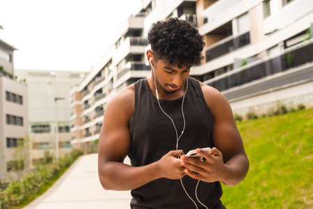 Arab young man doing sports in the city, preparing the music before trainingの写真素材