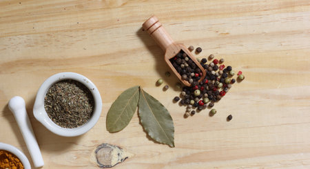 Mortar and Pestle With Herbs and Peppercorns on Wooden Background