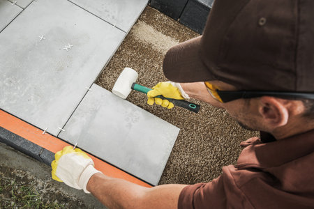 Professional Caucasian Worker in His 40s Building Concrete Bricks Path Inside Residential Garden. Industrial Theme.の写真素材