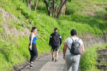 young latina woman very happy hiking with her family, mother with her two children going for a walk...