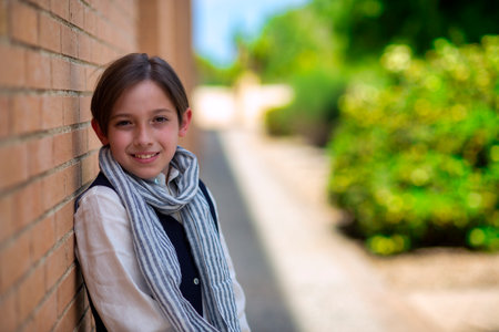 Child poses for fashion leaning on corner, sympathetic and laughingの写真素材