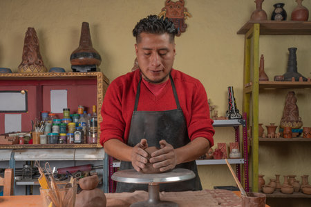 Focused potter working with clay in his workshop.の写真素材