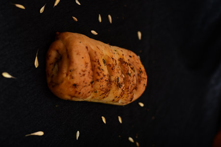 Bread roll and bunch of wheat on black background. food background concept.の写真素材