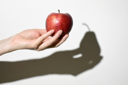Visual Dissonance Concept. Apple Fruit and Pear Fruit Shadowの写真素材