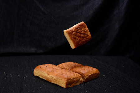 Bread pieces on black cloth background.