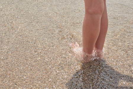 Girl's legs on the seashore during a sunny summer day, Vera, Spain
