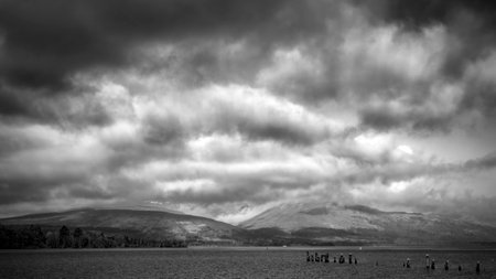 A dramatic panoramic view in black and white of Loch Lomond from Balloch in Scotland.の写真素材