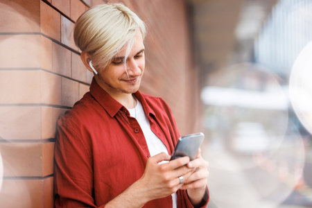 Man using a music service online. Young hipster with wireless headphones.の写真素材