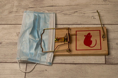 a mask caught in a mousetrap. end of the use of masks, end of the pandemic.