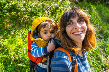Portrait of a young mother with a backpack looking at the Sella river between the Tornin a la Olla de San Vicente, near Cangas de Onis. Asturias. Spainの写真素材