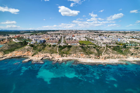 Aerial panoramic drone point of view Cabo Roig coastline with blue Mediterranean Seascape view, residential buildings near sandy beach at sunny summer day. Province of Alicante, Costa Blanca. Spainの写真素材