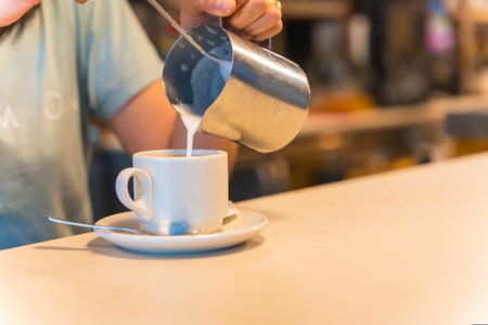 Unrecognizable female cafeteria waitress preparing coffee in a coffee machineの写真素材