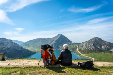 Grandmother, mother and son looking at Lake Enol in the Lakes of Covadonga. Asturias. Spainの写真素材