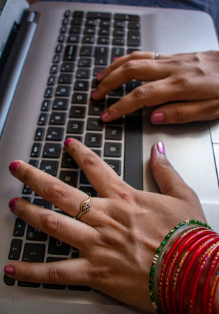Female working form home. wearing bangles.
