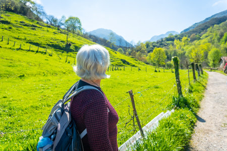 An elderly woman trekking on the trail between Tornin and Olla de San Vicente, near Cangas de Onis. Asturias. Spainの写真素材