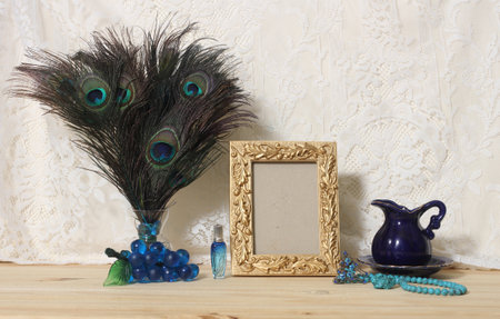 Vase of Peacock Feathers With Blue Jewelry and Gold Picture Frameの写真素材