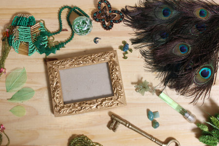 Green Jewelry and Peacock Feathers With Gold Picture Frame on Wood Back