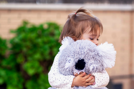 happy girl hugging her teddy tightの写真素材