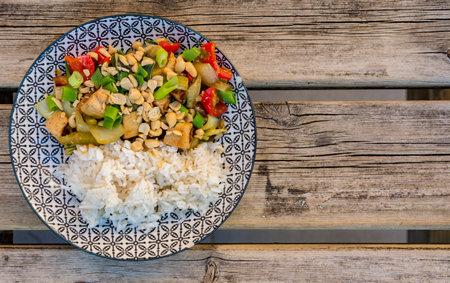 Vegan Asian dish with Tofu, vegetables and rice on weathered wooden table. Tasty food.の写真素材