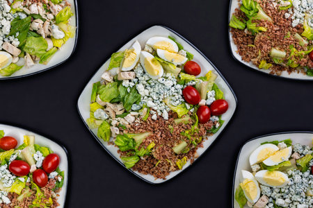 Assorted vegetable salad with tomatoes, eggs, bacon, french cheese Roquefort, chicken meat, lettuce.の写真素材