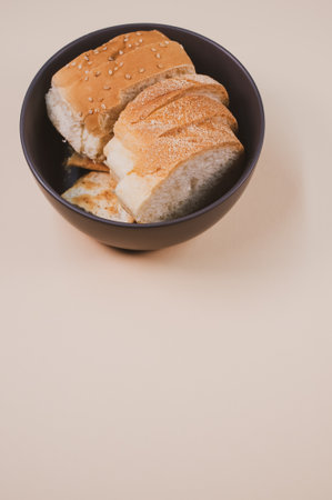 A bowl with bread slices isolated on a beige background with free space for textの写真素材