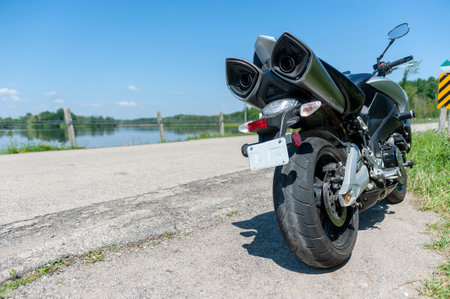 A motorbike parked on the edge of an asphalt road in summerの写真素材