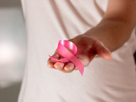 A closeup shot of a male holding the breast cancer symbolの写真素材