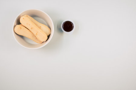 A top view of ladyfinger cookies on a plate with ketchup dip isolated on gray backgroundの写真素材