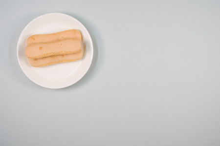 A top view of ladyfinger cookies on a plate isolated on gray backgroundの写真素材