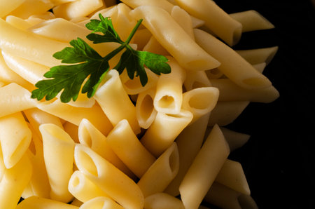 A high angle shot of delicious pasta with vegetables on a black surfaceの写真素材