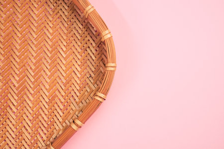 A top view of bamboo wicker tray isolated on pink backgroundの写真素材