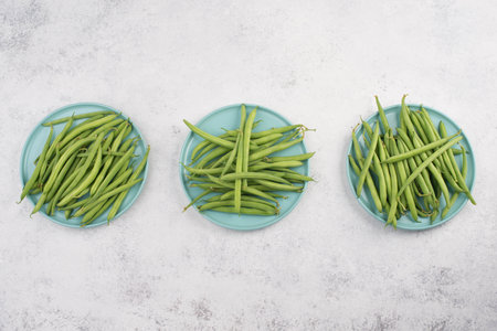 Green string beans on a  textured background, empty copy space for text, fresh vegetables