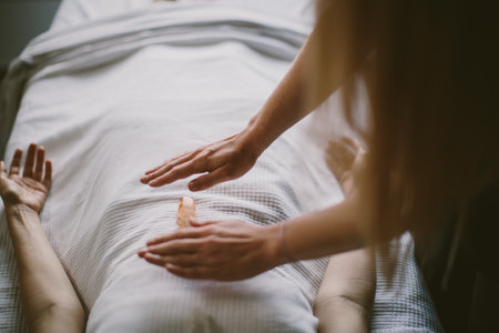 A Caucasian female massaging a client with a crystal stoneの写真素材