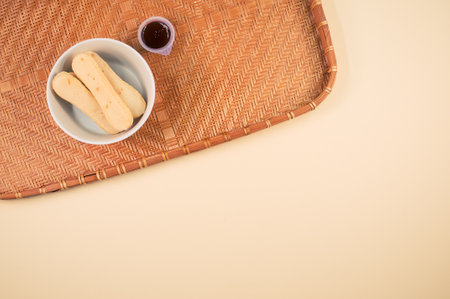 A top view of ladyfinger cookies with ketchup dip on a bamboo wicker tray isolated on pink backgroundの写真素材