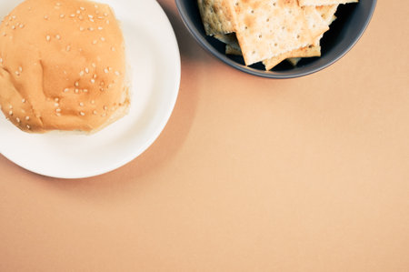 A top view shot of a tasty bun and bread chips on an orange backgroundの写真素材
