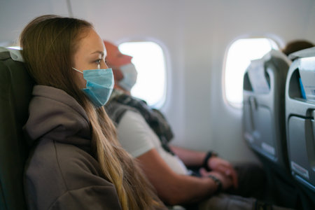 Young lady wearing face mask on airplane