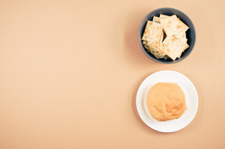 A top view of square crackers and bread bun isolated on light brown backgroundの写真素材