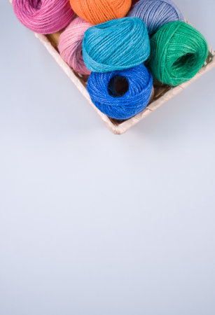 A basket full of colorful yarn rolls isolated on a white background with free space for textの写真素材
