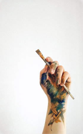 A hand holding a painting brush isolated on a white backgroundの写真素材