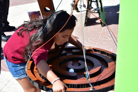 A Hispanic girl playing a board game with a ballの写真素材