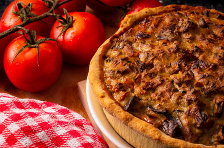 A high angle shot of traditional food with crust, meat, cheese, and fresh tomato
