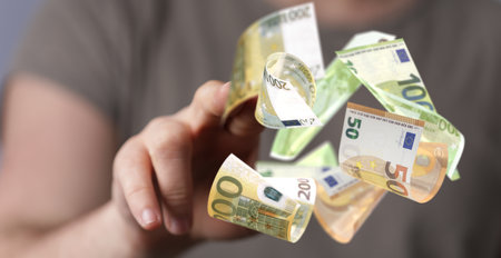 Some falling euro banknotes presented by a personの写真素材