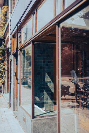 A vertical shot of a building glass facade with reflected motorcycle and street viewの写真素材