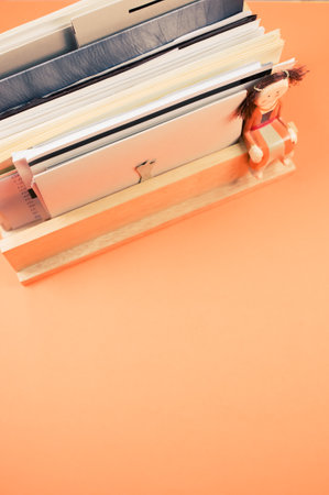 A vertical shot of filled documents on a wooden shelf isolated on an orange backgroundの写真素材